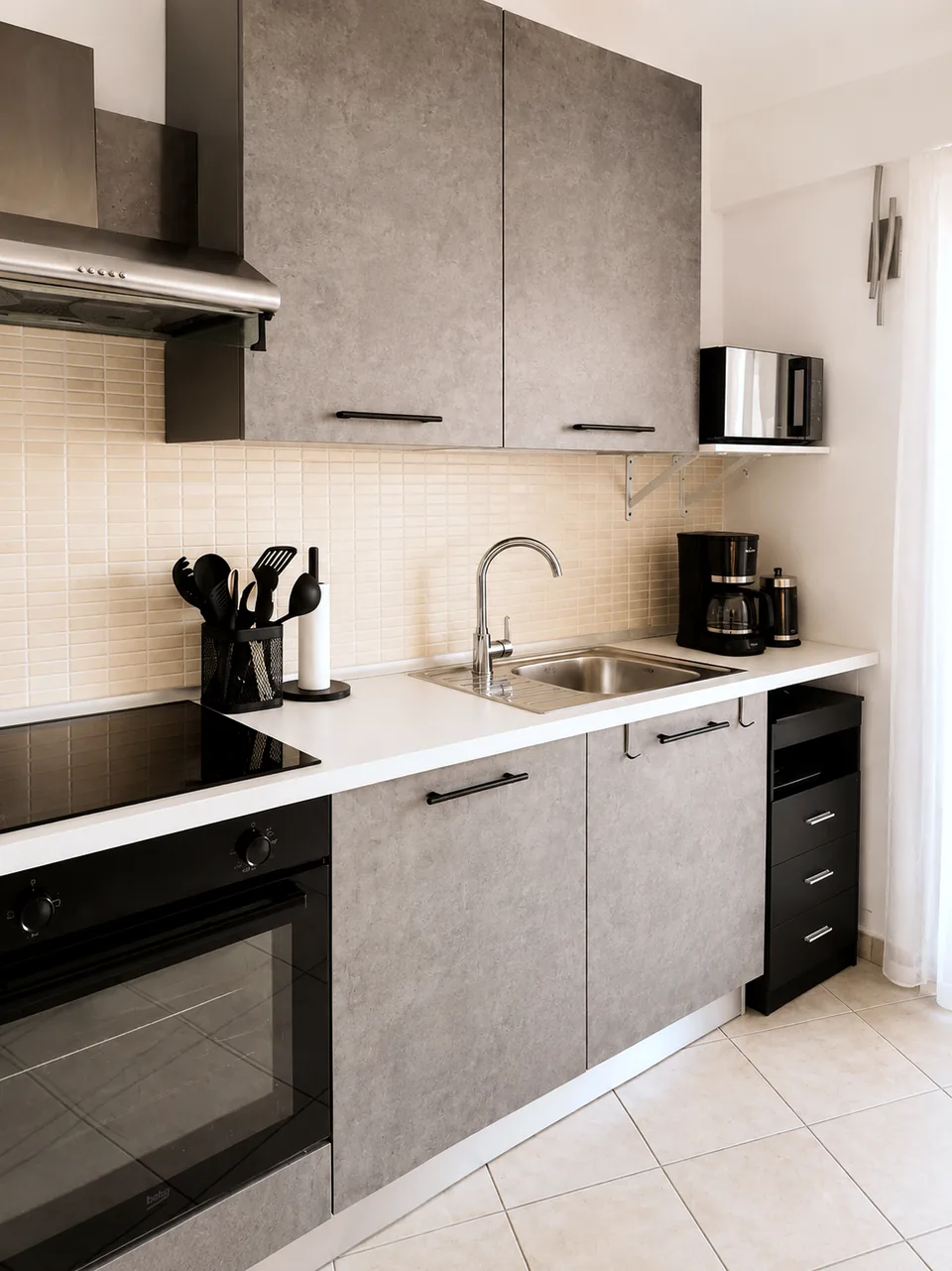 Fully equipped kitchen counter with sink, filter coffee machine and utensils