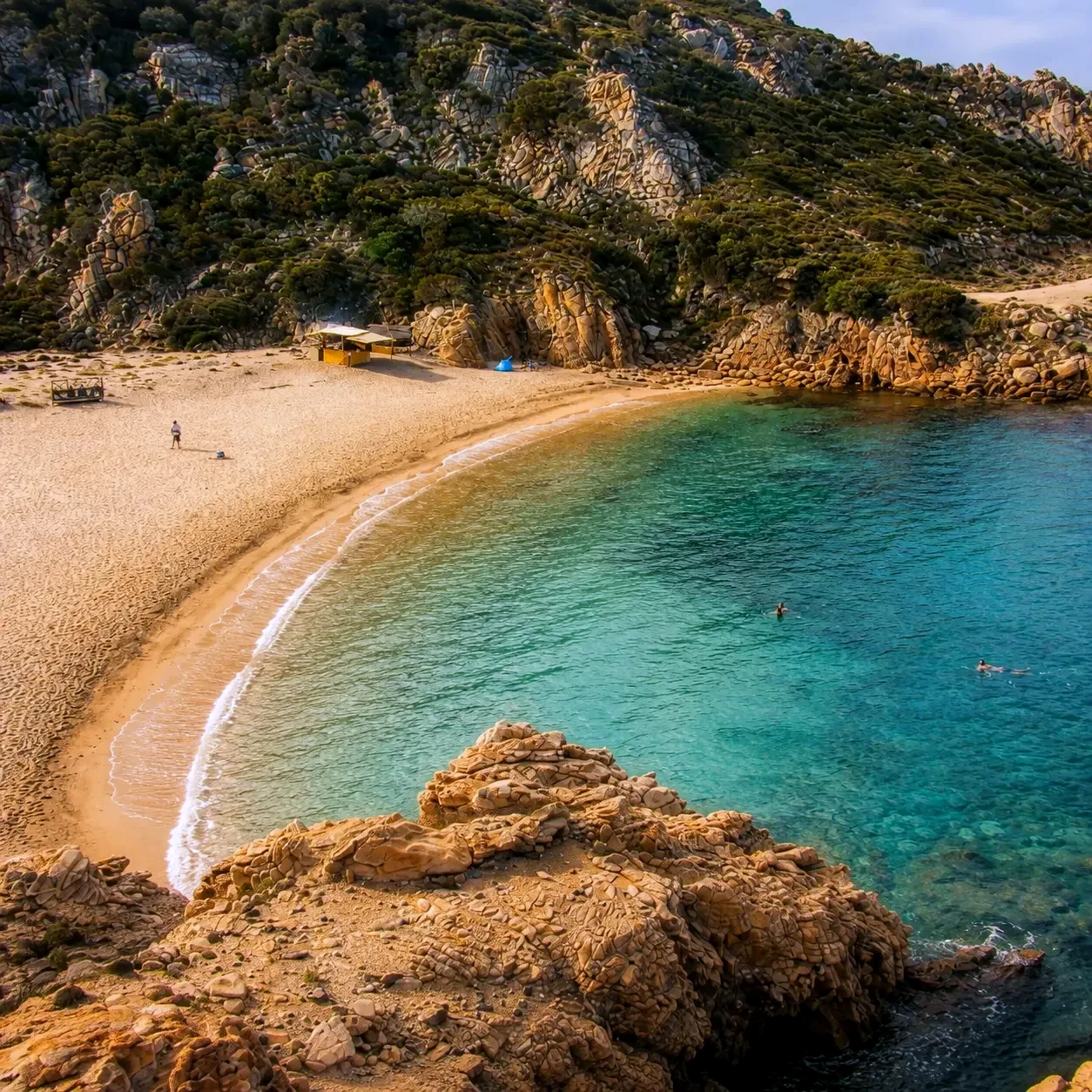 Une crique abritée aux eaux turquoise avec un unique kiosque de plage