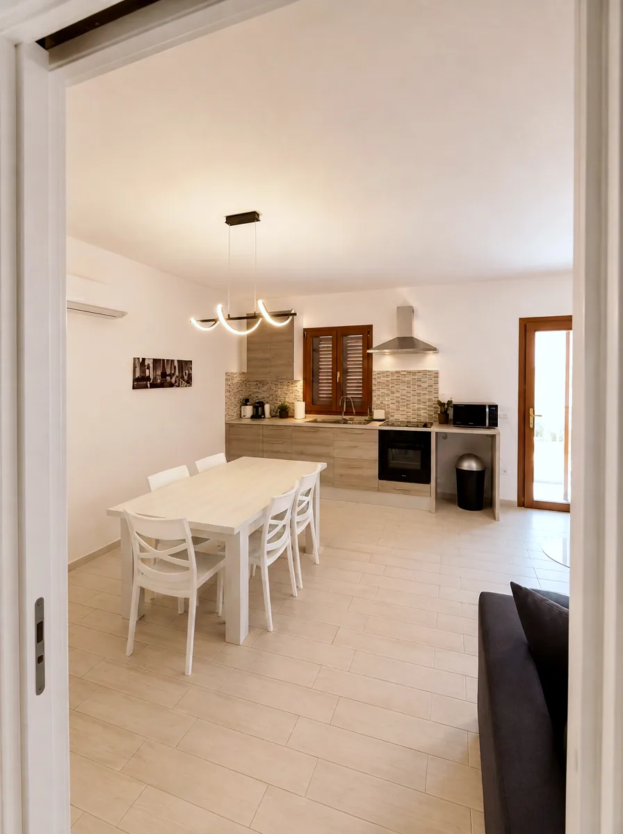 View from the hallway into the dining area and fully equipped kitchen with oven, hob and microwave at La Dolce Vita