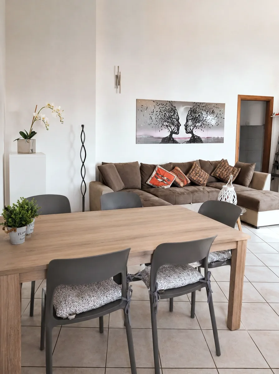 Dining table for six with orchid and artwork, looking through to the lounge