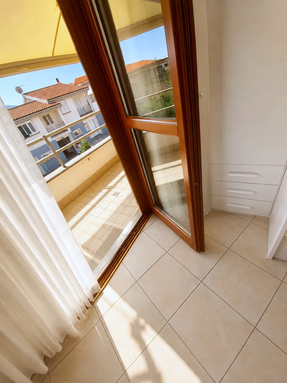 Rear balcony doors open from the second bedroom onto the sunlit back balcony
