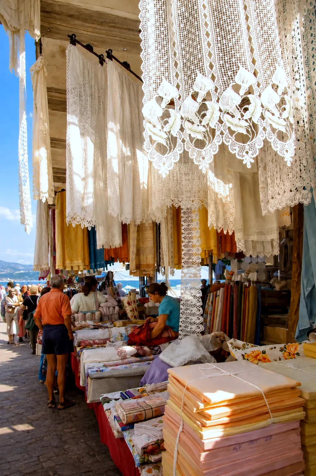 Dentelles et linges faits main sur un étal de marché en bord de mer