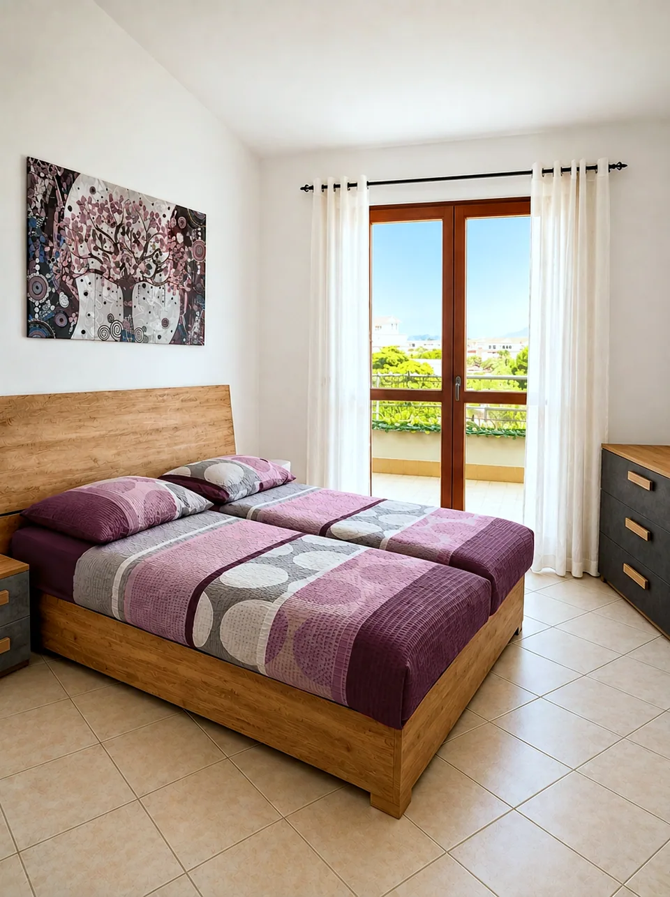 Master bedroom with twin beds and balcony doors opening to sea and village views