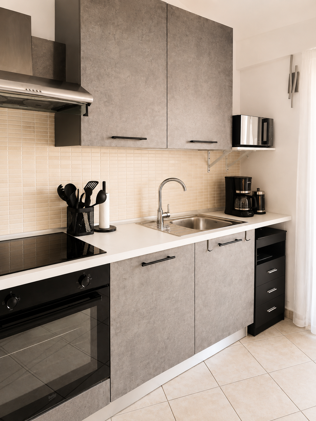 Fully equipped kitchen counter with sink, filter coffee machine and utensils